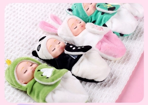 Close-up of four reborn sleeping dolls in plush frog, rabbit, and panda outfits