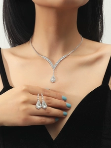 Close-up of bridal jewelry set with pear-cut zircon necklace and earrings on model
