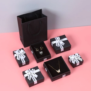 Detail of black lychee textured jewelry gift boxes and matching paper carry bag
