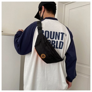 Detail view of black oxford chest bag with orange contrast and adjustable shoulder strap
