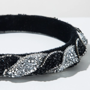 Dettaglio del cerchietto in velluto nero con strass argentati brillanti a righe