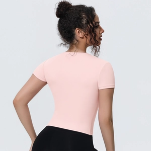 Detail of slim fit light pink yoga t-shirt showing breathable fabric and elastic waist
