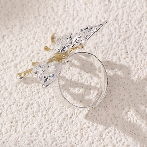 Macro view of adjustable butterfly ring with two-tone silver and gold plated metal details