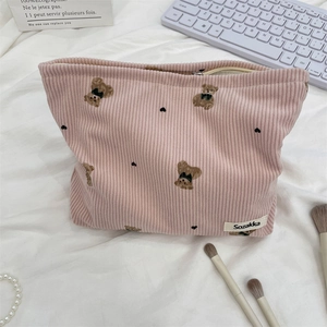 Detailed shot of pink corduroy pouch with cute bear pattern on white wrinkled cloth