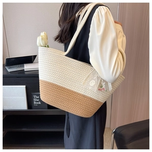 Detail of hand-woven tote bag with lace flower pendant and stylish two-tone texture