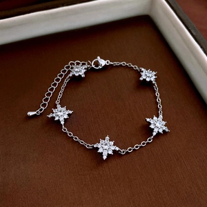 Detail of silver star zircon bracelet with five sparkling hexagrams on leather background