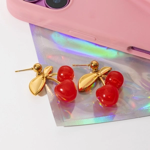 Detail of sweet cherry drop earrings in 18K gold plated steel and red glossy finish