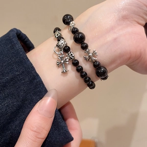 Vue détaillée des bracelets en perles d'onyx noir avec pendentifs croix gothiques