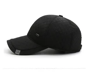 Detail view of winter baseball cap featuring black quilted windproof fabric and sport label