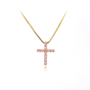 Detailed view of a gold cross pendant necklace set with vibrant pink round cubic zirconia