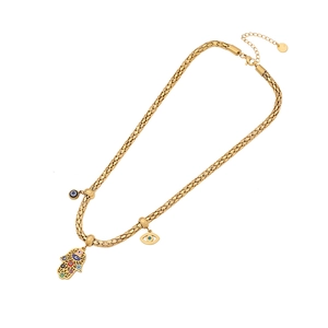 Gold chunky chain necklace with Hamsa hand and evil eye charms on white background