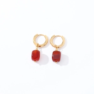 Detail view of gold hoop earrings with square red carnelian gemstone pendants
