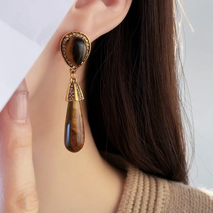Close-up of vintage bronze double teardrop earrings featuring brown tiger eye stones