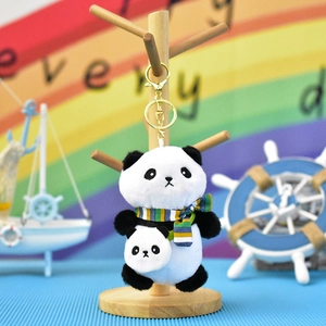 Detailed view of a cute panda plush keychain with striped scarf and mini backpack