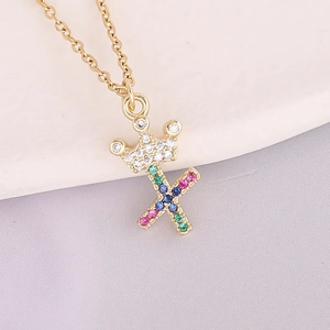 Detailed macro shot of 18K gold plated necklace with crown and letter X zircon pendant