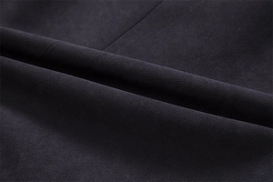 Macro shot of dark grey woven wool fabric showing twill texture and premium drape quality
