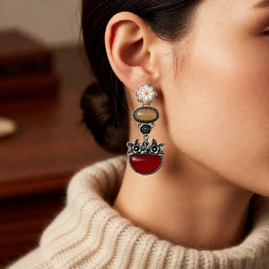 Close-up of vintage floral drop earrings with colorful stones on a female model