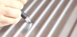 Detailed close-up of water ripple metal sheet surface with a pen testing texture