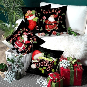 Set of four Christmas pillow covers featuring Santa and festive motifs on a white sofa