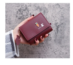 Detail of burgundy leather wallet with carrot hardware and cute bunny design