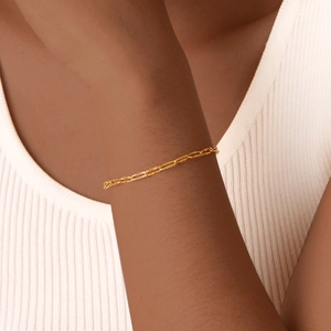 Detail of 18K gold plated stainless steel bracelet with textured oval links on female wrist