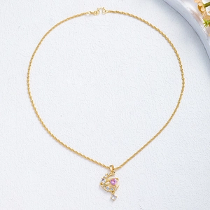 Detail of moon and star pendant with pink heart gemstone and sparkling cubic zirconia
