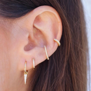 Golden geometric cone earrings with sparkling crystals shown worn on ear for women