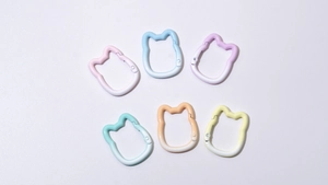 Close-up of cat-shaped gradient spring ring buckles for DIY keychains in six pastel colors