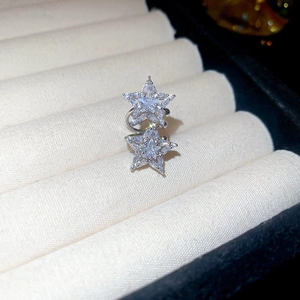 Macro view of twin star ear cuff inlaid with sparkling zircons on velvet jewelry display