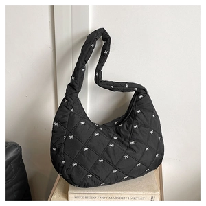 Detail einer schwarzen Stepptasche mit weißem Schleifenmuster und Nylon-Textur