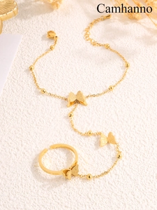 Detail of a golden butterfly ring-bracelet combo with a brushed matte metallic finish
