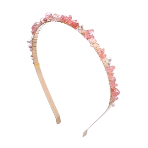 Close-up of pink natural stone chips hand-wrapped on a golden metal headband