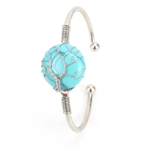 Macro shot of handmade silver wire wrapped tree of life turquoise on open bangle bracelet