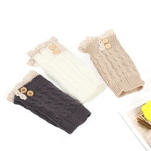 Close-up of knit leg warmers with lace trim and wooden buttons in grey, beige, and khaki
