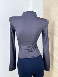 Rear view of a slim-fit dark gray long-sleeved athletic top with a high collar on a mannequin