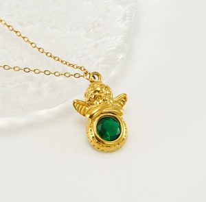 Detailopname van een 18k vergulde cherubijn hanger met een grote groene ovale edelsteen
