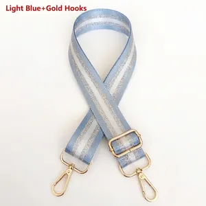 Detail of adjustable light blue nylon strap with silver stripes and gold metal swivel hooks