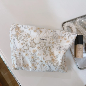 Close-up of floral rabbit pattern cotton cosmetic bag with 'simple wish' fabric label