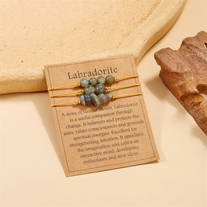 Detailed macro view of Labradorite beaded bracelets with yellow woven cord and kraft card