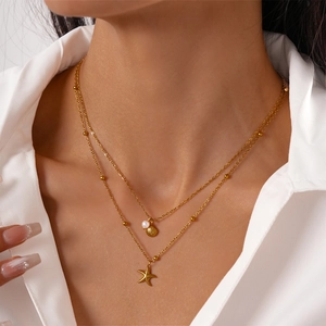 Golden double layer necklace featuring starfish, shell and pearl charms for beach vacations