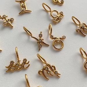 Detalle de cerca de colgantes de zodiaco dorados con piedras de circonita brillantes