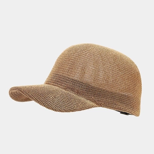 Detailed view of the woven texture on a brown straw baseball cap from a side angle