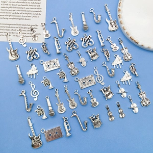 Detailed collection of silver alloy musical instrument charms on light blue surface