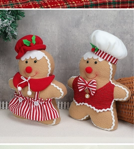 Detailed view of plush gingerbread man and woman figurines with festive chef hats