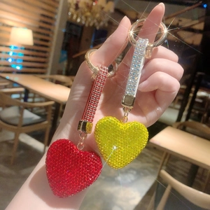 Close-up of heart-shaped keychain with red and yellow rhinestones and gold lobster clasp