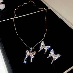 Close-up of butterfly necklace and earrings set with green zircon in a gift box