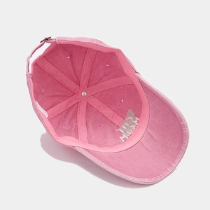 Detailed interior of a pink cotton baseball cap showing the sweatband and metal buckle