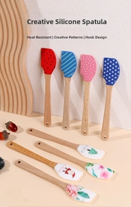 Silicone spatulas with wooden handles and festive patterns featuring a storage hanging hole