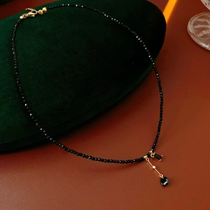 Detailed view of black faceted crystal beads and gold pendant on vintage choker necklace