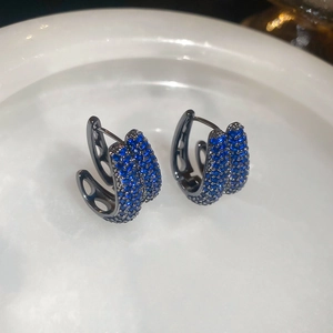 Detailed close-up of C-shaped earrings with black plating and micro-pave blue cubic zirconia